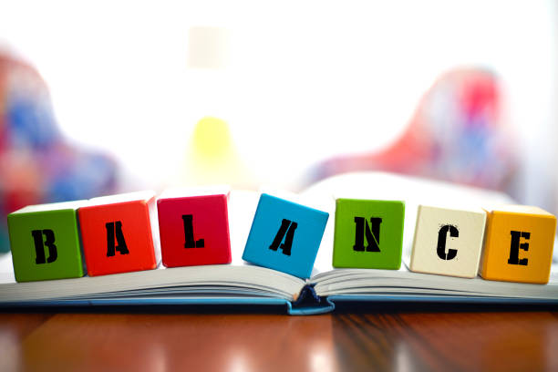 BALANCE,  word Concept with Seven building blocks placed on the open book