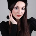 Happy woman in black fur hat and ring