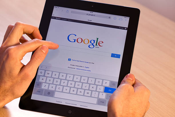 Milan, Italy - November 10, 2013: Womans holding an Apple iPad displaying Google. The iPad is produced by Apple Computer, Inc. Description